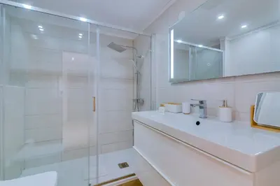 a white bathroom with a sink and a shower at Apartamento Al Sakia 2bdr com piscina e ar condicionado in Quarteira