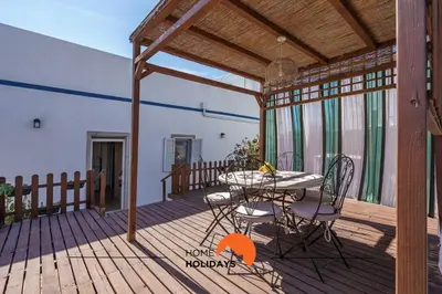 a patio with a table and chairs on a deck at #236 Texugueiras 148 by Home Holidays in Ferreiras