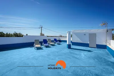 a pool with chairs on the roof of a building at #236 Texugueiras 148 by Home Holidays in Ferreiras