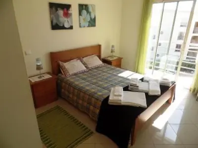 a bedroom with a bed and a table with towels at Encosta Do Sol in Albufeira