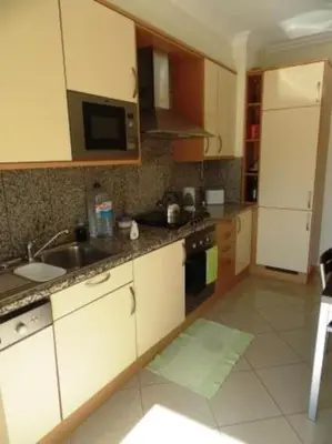 a kitchen with a sink and a microwave at Encosta Do Sol in Albufeira