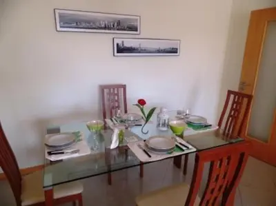a dining room table with chairs and a glass table top at Encosta Do Sol in Albufeira