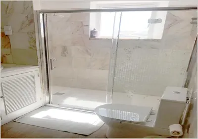 a bathroom with a shower with a toilet and a window at Windmill Hill - Alto do Moinho - Pool & Sea View in Albufeira