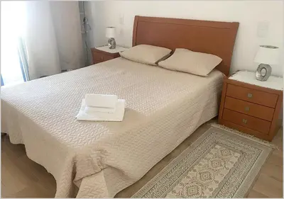 a bedroom with a large bed with two night stands and two tables at Windmill Hill - Alto do Moinho - Pool & Sea View in Albufeira