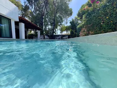 a swimming pool with blue water in front of a house at Vilamoura Premium Villa With Pool by Homing in Vilamoura