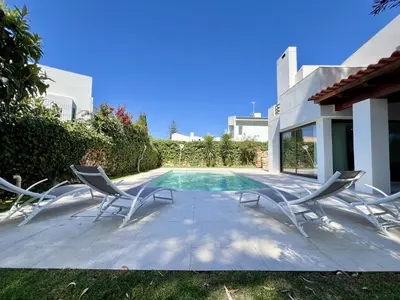 a group of chairs sitting next to a swimming pool at Vilamoura Premium Villa With Pool by Homing in Vilamoura