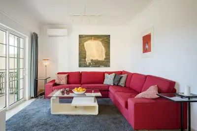 a living room with a red couch and a table at Villa Nascente Balaia in Branqueira