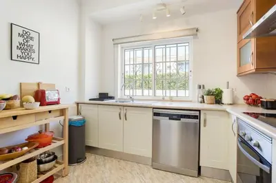 a kitchen with white cabinets and a window at Villa Nascente Balaia in Branqueira