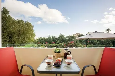 a table and chairs on a balcony with an umbrella at Villa Nascente Balaia in Branqueira