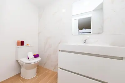 a white bathroom with a toilet and a sink at Villa Palancar by Algarve Vacation in Albufeira