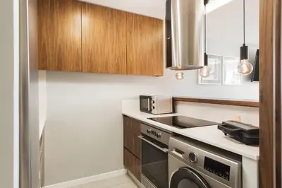 a kitchen with a stove and a washer and dryer at SeaVillage Asia - City Center by HD in Vilamoura