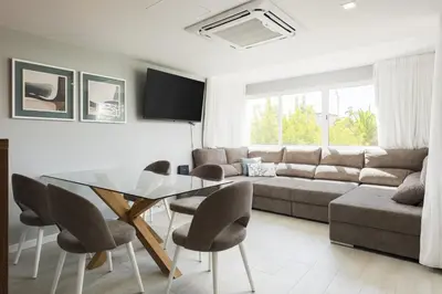 a living room with a glass table and chairs at SeaVillage Asia - City Center by HD in Vilamoura