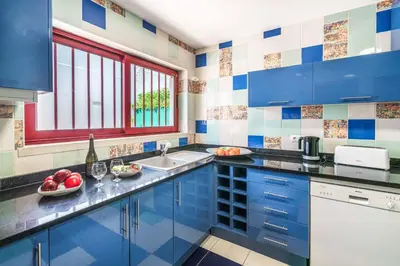 a kitchen with blue cabinets and a sink at Villa Malibu Marina in Albufeira