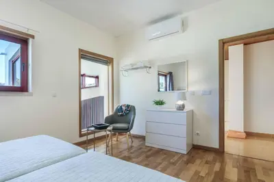 a bedroom with a bed and a chair and a desk at Villa Malibu Marina in Albufeira