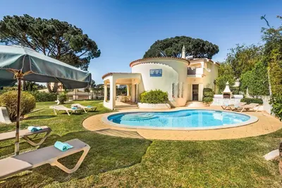 a house with a large swimming pool in front of it at Casa Paraiso in Vilamoura