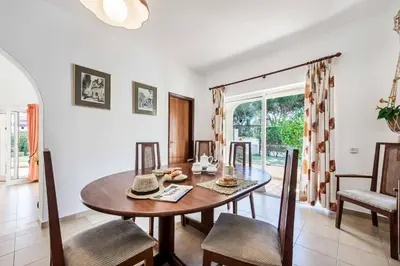 a dining room with a wooden table and chairs at Casa Paraiso in Vilamoura