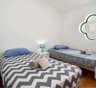 a bedroom with two beds and a mirror on the wall at Casa Vila Sul AE in Roja- Pé