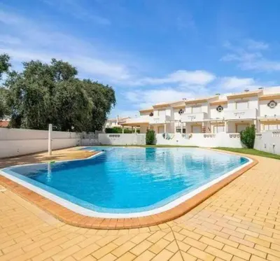 a large blue swimming pool in front of a building at Casa Vila Sul AE in Roja- Pé