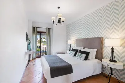 a bedroom with a large bed and a chandelier at Cosy Apartment with Pool 1 in Vilamoura