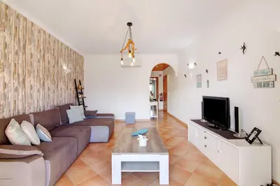 a living room with a couch and a tv at Cosy Apartment with Pool 1 in Vilamoura
