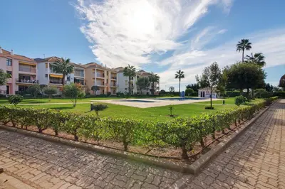 a park in a resort with palm trees and buildings at Cosy Apartment with Pool 1 in Vilamoura
