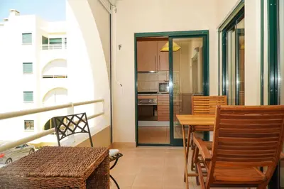 a kitchen and dining room with a table and chairs at Salgados Apartment in Albufeira