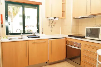 a kitchen with a sink and a microwave at Salgados Apartment in Albufeira