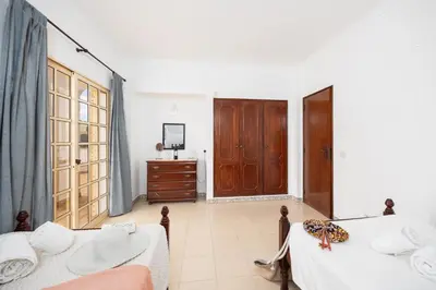 a living room with a bed and a dresser and a door at Villa Baltin in Albufeira
