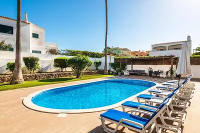 a group of lounge chairs and a swimming pool at Villa Baltin in Albufeira