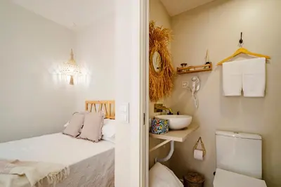 a small bathroom with a bed and a sink at Casas das Ilhas in Faro