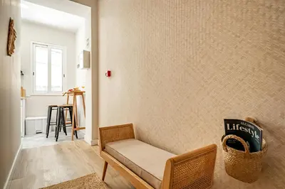 a living room with a bench and a wall at Casas das Ilhas in Faro