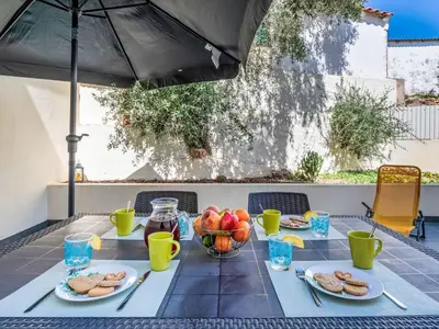 a table with food and drinks on a patio at Holiday Home Vila Parra by Interhome in Galé