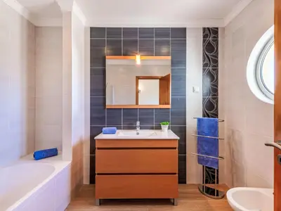 a bathroom with a sink and a tub and a mirror at Holiday Home Vila Parra by Interhome in Galé