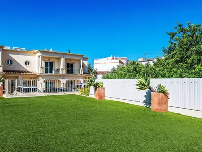 a house with a white fence and a green yard at Holiday Home Vila Parra by Interhome in Galé