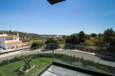 two chairs on a balcony with a view of a city at Dalma- Villa da Ourada in Sesmarias