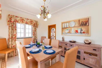 a dining room with a wooden table and chairs at Villa Agadir by Algarve Vacation in Albufeira