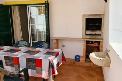 a room with a table and chairs and a tv at Vila Rafaella - Praia de São Rafael in Sesmarias