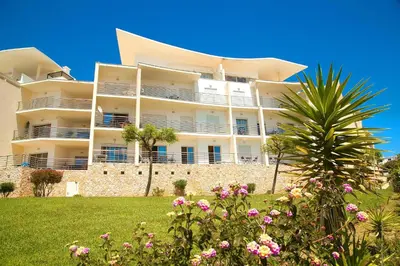 a large white building with flowers in front of it at Sea View Apartment by Be Cherish in Albufeira