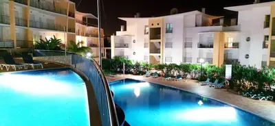 a swimming pool in front of a building at night at Sea View Apartment by Be Cherish in Albufeira