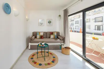 a living room with a couch and a table at Casas Barulho Apartment Old Town in Albufeira