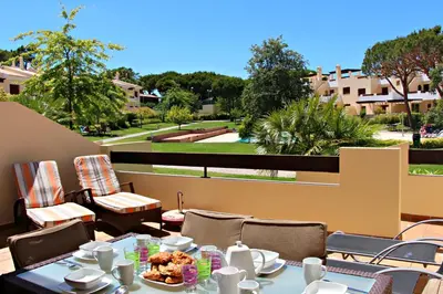 a table with plates of food on a balcony at Vilamoura Typical 3 With Pool by Homing in Quarteira