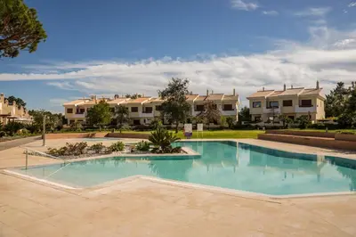 a swimming pool in a yard with houses in the background at Vilamoura Typical 3 With Pool by Homing in Quarteira
