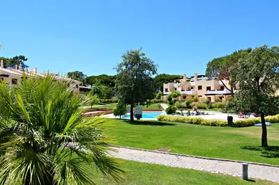 a park with a pool and trees and buildings at Vilamoura Typical 3 With Pool by Homing in Quarteira