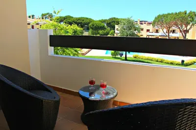 two glasses of wine sitting on a table in front of a window at Vilamoura Typical 3 With Pool by Homing in Quarteira