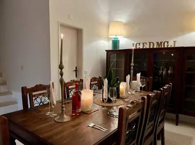 a wooden table with chairs and a long table with candles at Casa de Limoeiro - Countryside Villa in Córregos de Santa Luzia