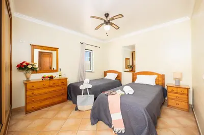 a bedroom with two beds and a ceiling fan at Villa Santa Maria in Albufeira