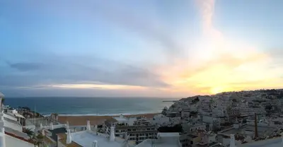 a view of a city and the ocean at sunset at Fantastic view over the sea in Albufeira