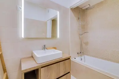 a bathroom with a sink and a mirror and a tub at Apartamento Farol com piscina e estacionamento in Vilamoura