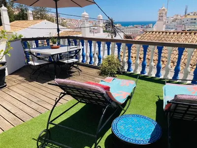 a balcony with a table and chairs and an umbrella at Villa 2BDR with sea view, private pool in Albufeira