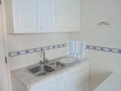 a kitchen with a sink and white cabinets at Albufeira INN - Mulatinho V2 in Olhos de Água